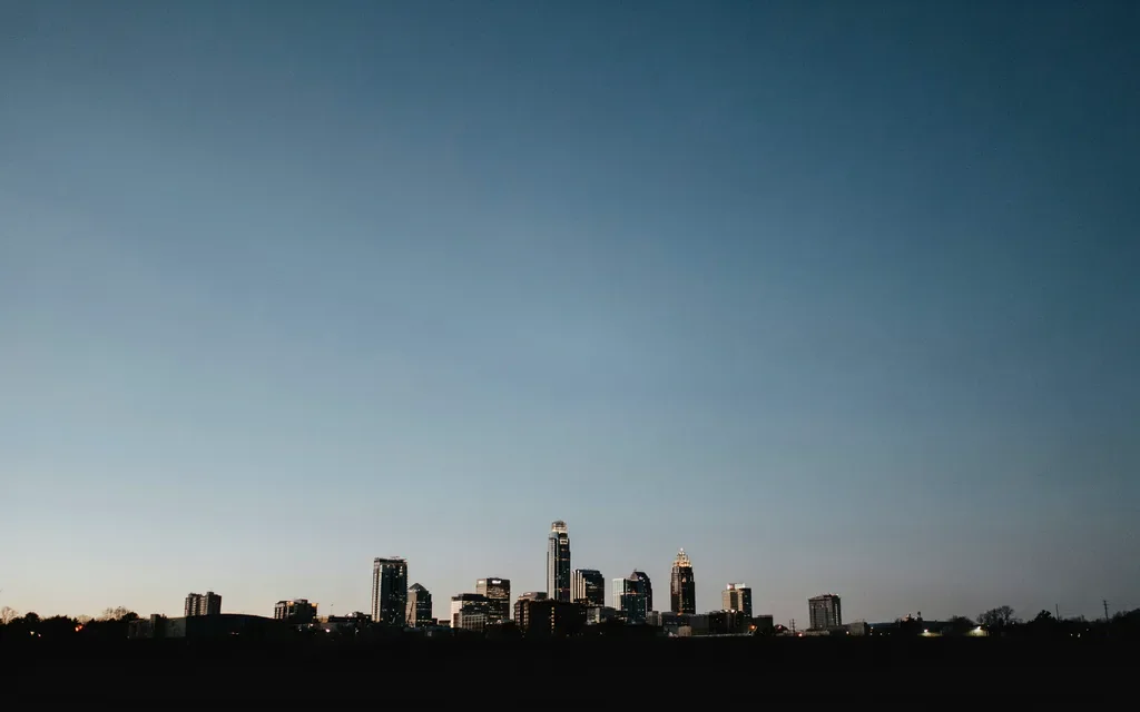 The Charlotte skyline in silhouette at dusk